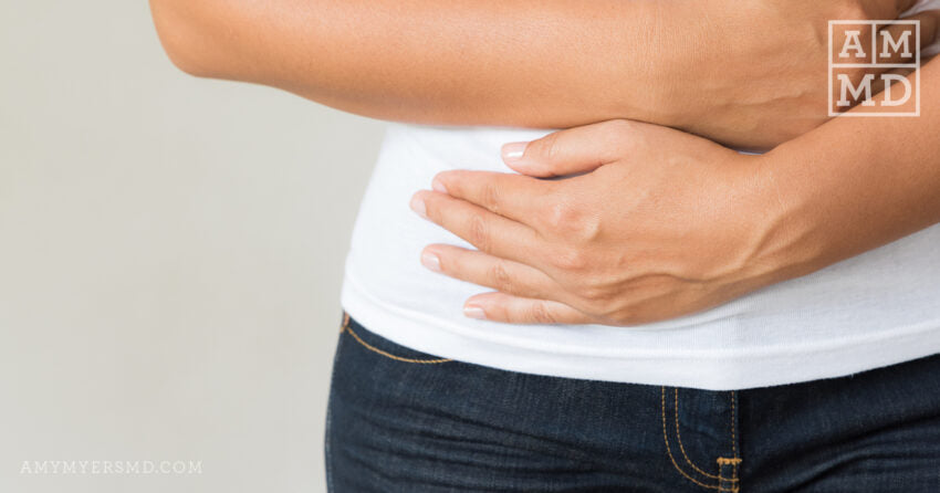 Person holding stomach - SIBO Bloating & How to Overcome It - Amy Myers MD®