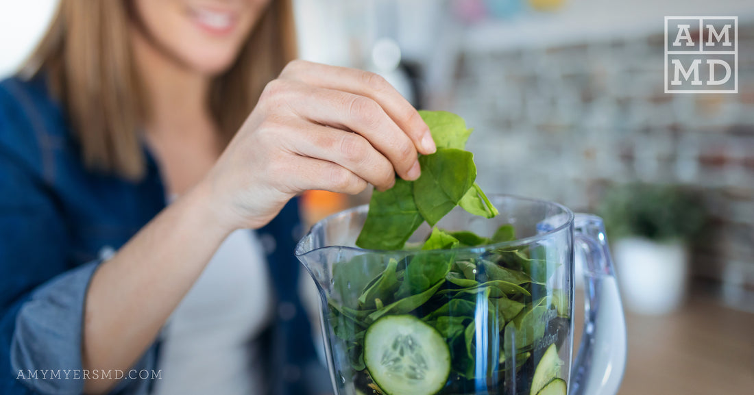 Woman adding spinach to a blender - 5 Foods To Fight Gas and Bloating - Amy Myers MD®