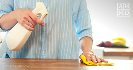 Person cleaning a counter with cleaning spray - Tame the toxins - Amy Myers MD®